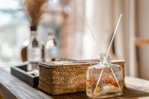 a glass vase with flowers in it next to a basket at Baisha Flamingo Hotel in Lijiang