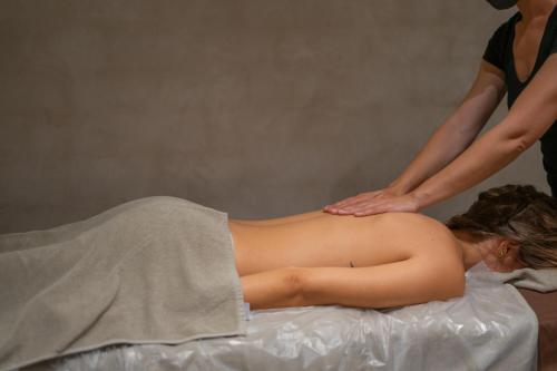 a woman getting a back massage from a therapist at La Residencia Puerto Hotel & Spa in Tarifa