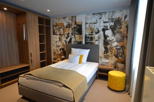 a bedroom with a bed with a poster on the wall at Boutique Hotel Moselgarten in Bullay