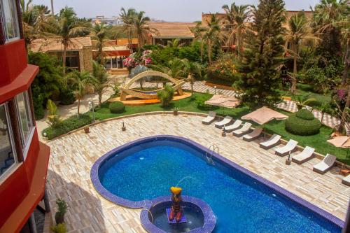 an overhead view of a swimming pool with lounge chairs and a resort at Iris Hotel in Dakar