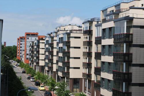 un edificio alto con balcones en una calle de la ciudad en Gandrališkės apartamentai, en Klaipėda