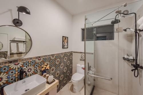 a bathroom with a shower and a toilet and a sink at Baisha Flamingo Hotel in Lijiang