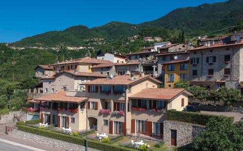 a group of houses on a hill with mountains in the background at Residence Calap in Tignale