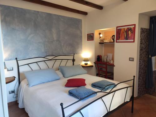 a bedroom with a white bed with blue and red pillows at Pietra Di Mare in Biassa