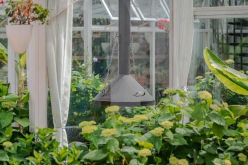 a hanging bell in a greenhouse with flowers at Baisha Flamingo Hotel in Lijiang