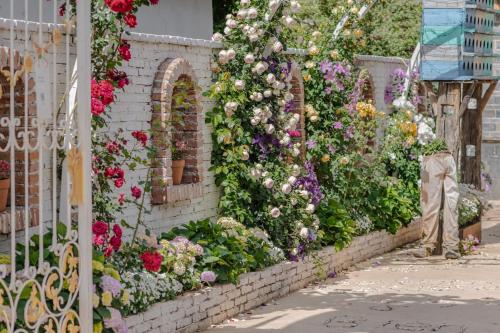a wall of flowers on a brick wall at Baisha Flamingo Hotel in Lijiang