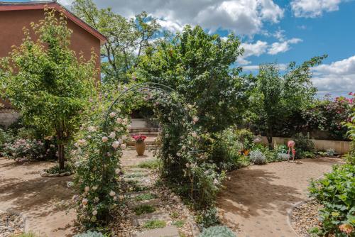 an archway in a garden with flowers at Baisha Flamingo Hotel in Lijiang