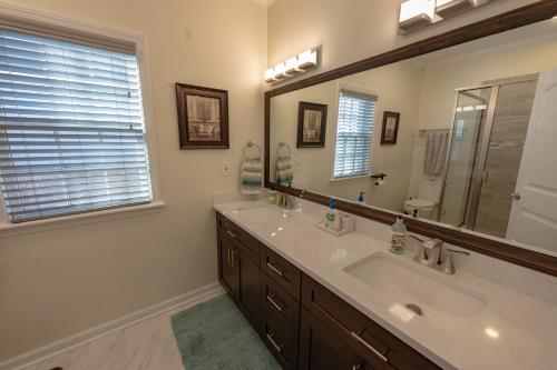 a bathroom with two sinks and a large mirror at Remodeled Historic House Walkable to Everything in Raleigh