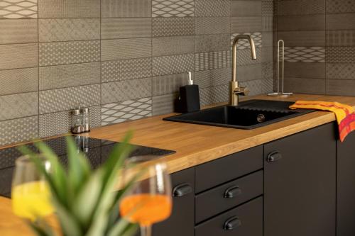 a kitchen with a sink and a counter top at Provence Au Coeur Appart Hotels in Forcalquier
