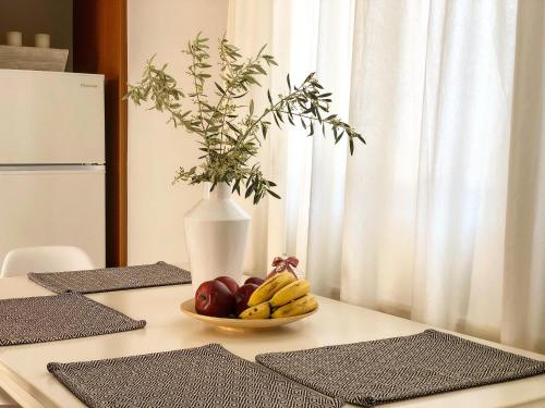 een fruitschaal op een tafel met een vaas bij Helianthus Apartments in Argostoli