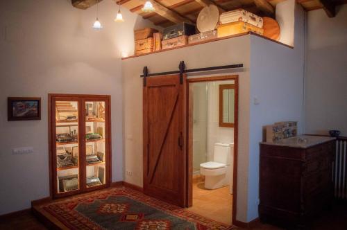a bathroom with a toilet and a wooden door at Mas Teixidor, Masia entre Girona y la Costa Brava in Caldes de Malavella