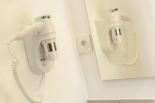 a hospital room with a phone on a wall at Provence Au Coeur Appart Hotels in Forcalquier