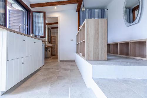 a kitchen with white cabinets and a staircase at La stanza di Vali in Sperlonga