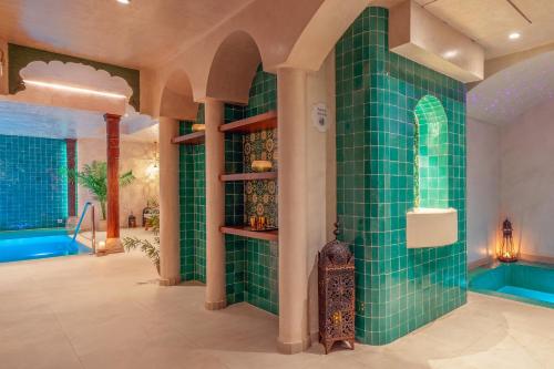 a bathroom with green tiled walls and a tub at La Residencia Puerto Hotel & Spa in Tarifa