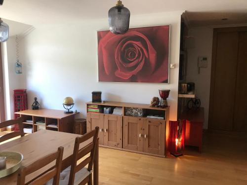 a dining room with a table and a red rose on the wall at NOTRENiD in Porriño