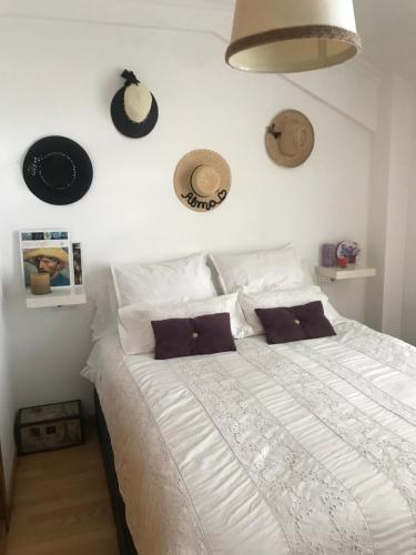 1 dormitorio con 1 cama con sombreros en la pared en NOTRENiD, en Porriño