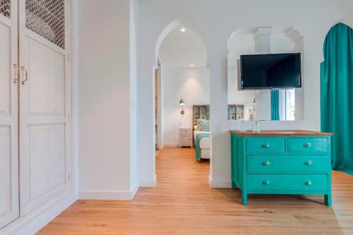 a room with a blue dresser and a bedroom at La Residencia Puerto Hotel & Spa in Tarifa