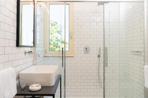 a white bathroom with a sink and a shower at Leopoldo Rooms in Cagliari