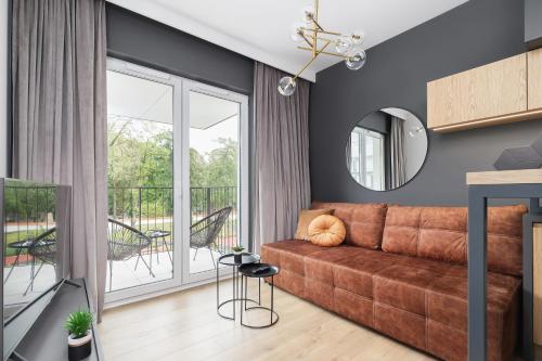a living room with a couch and a balcony at Apartments Steam Park Old Town Cracow by Renters in Krakow