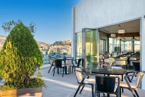 a patio with tables and chairs on a balcony at The Stanley in Athens