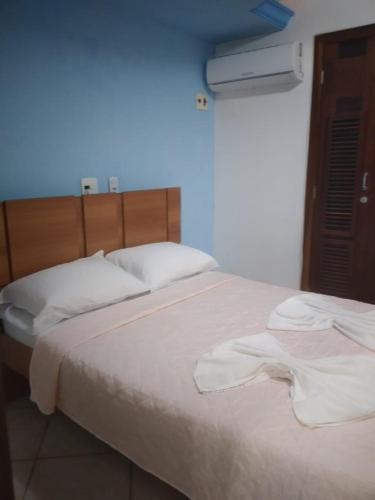 a bedroom with a large bed with white sheets at PontaNegra PontadoSolluciene 4B in Natal