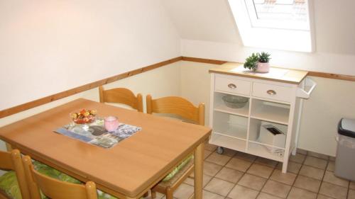 カロリーネンジールにあるFerienwohnung Wattwurmのダイニングルーム(テーブル、椅子、キャビネット付)