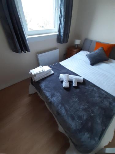 1 Schlafzimmer mit 2 Handtüchern auf einem Bett in der Unterkunft Carvetii - Stuart House - 1st floor flat sleeps up to 8 in Falkirk