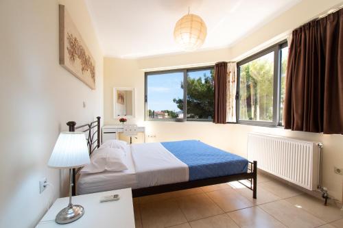 a bedroom with a bed and a window at Apartments Efi in Artemida