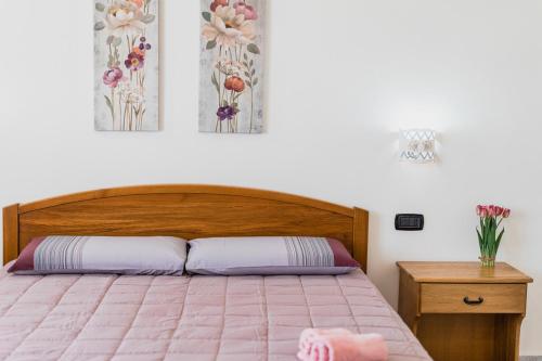 a bedroom with a bed with a pink comforter at La luna nel pozzo in Portoscuso