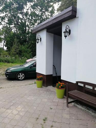 a green car parked next to a building with a bench at NOCLEGI u ALI in Wałbrzych