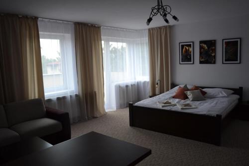 sypialnia z łóżkiem, krzesłem i stołem w obiekcie Apartament Szaława w Kaliszu