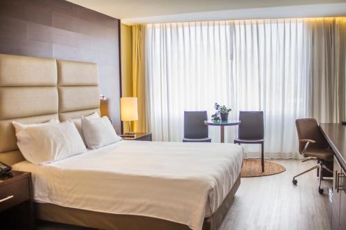 Ein Bett oder Betten in einem Zimmer der Unterkunft Hotel Estelar Milla De Oro