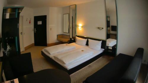 Ein Bett oder Betten in einem Zimmer der Unterkunft Hotel Bitterfelder Hof