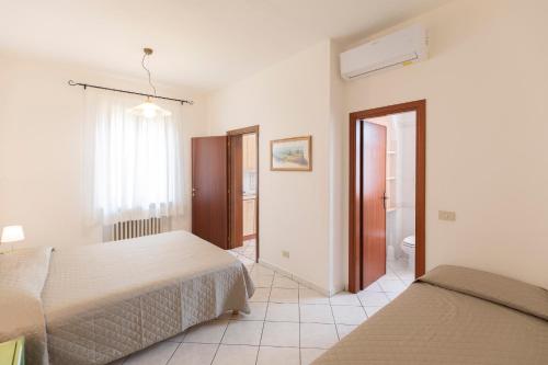 a bedroom with two beds and a bathroom at HelloElba Appartamento Azzurro in Marina di Campo