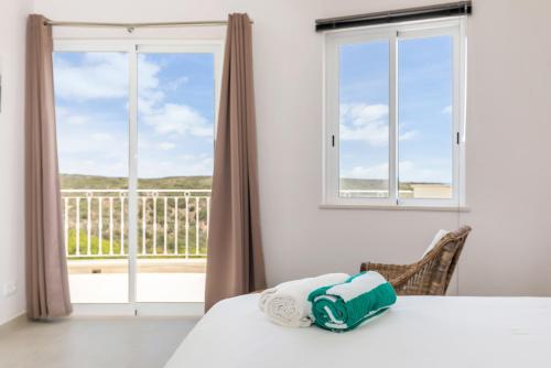 sypialnia z łóżkiem i dużym oknem w obiekcie Sea View Villa w mieście Sagres
