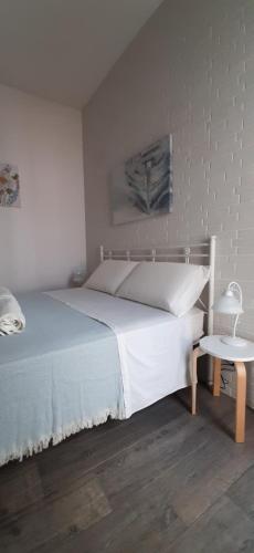 サンタ・マリア・アル・バーニョにあるCasa Carlottaのベッドルーム(白いベッド1台、サイドテーブル付)