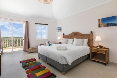 a bedroom with a large bed and a balcony at Sea View Villa in Sagres