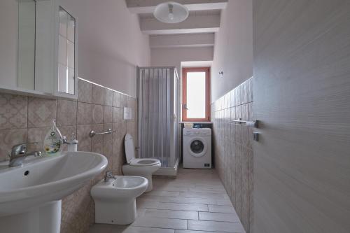 a bathroom with a sink toilet and a washing machine at La rosa dei venti, apartment 3 in Porto Empedocle