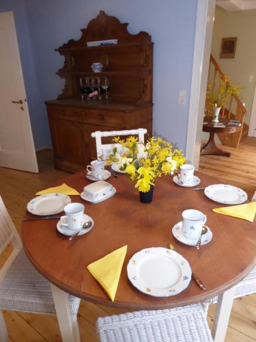 a wooden table with plates and flowers on it at Forsthaus in Waldhessen in Bauhaus
