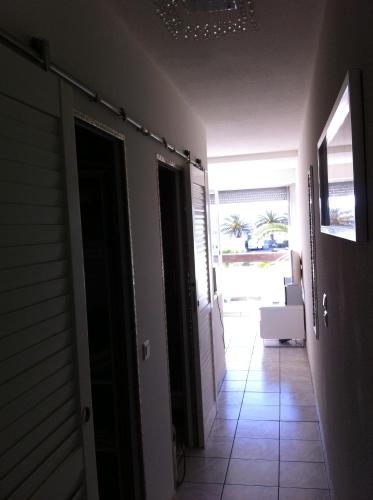 un couloir avec une porte menant à une chambre dans l'établissement Appartement village naturiste, port nature , cap d'agde, chic, au Cap d'Agde