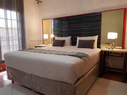 a bedroom with a large bed with a large headboard at Aloe 40 in Burgersfort
