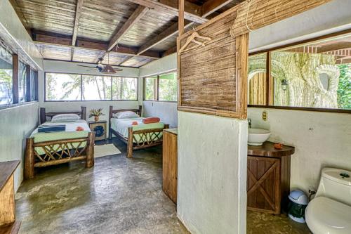 a bathroom with two beds and a sink and a toilet at Casa Verde in Cabo Matapalo