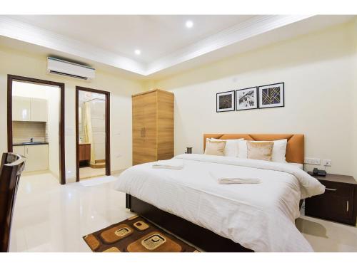 1 Schlafzimmer mit einem großen Bett und einem Badezimmer in der Unterkunft BluO Studio1 Golf Course Road, Gym, Balcony Garden in Gurgaon