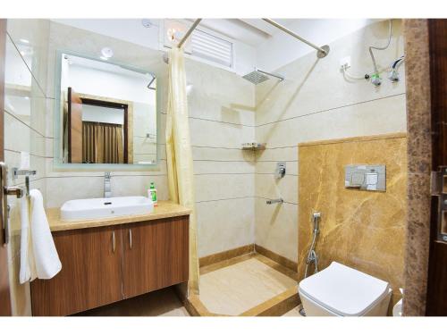 uma casa de banho com um chuveiro, um lavatório e um WC. em BluO Studio1 Golf Course Road, Gym, Balcony Garden em Gurgaon