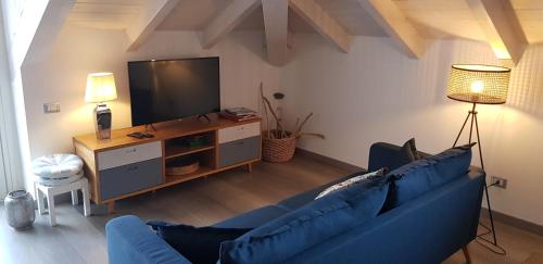 ein Wohnzimmer mit einem blauen Sofa und einem TV in der Unterkunft Bellagio Holiday Home in Bellagio