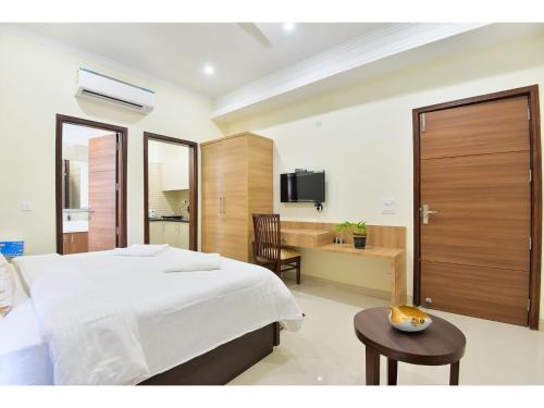 um quarto com uma cama e uma secretária com uma televisão em BluO Studio2 Golf Course Road - Gym, Terrace Garden em Gurgaon