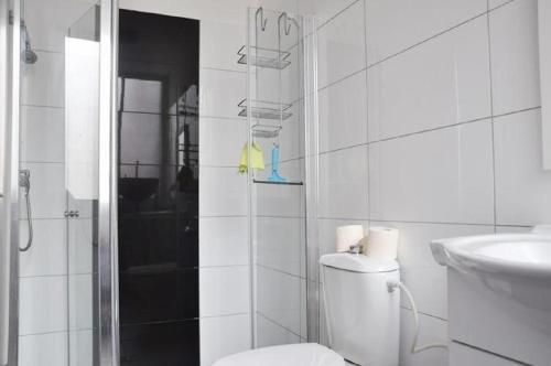 a white bathroom with a toilet and a sink at Apartment Harmony in Bat Yam