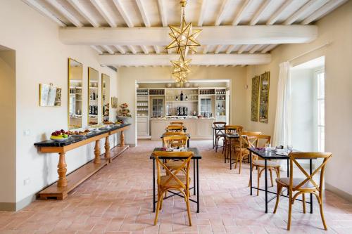 uma sala de jantar com mesas e cadeiras e um lustre em La Pietra Del Cabreo em Greve in Chianti