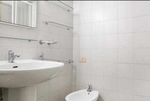 a white bathroom with a sink and a toilet at MELLINI HOUSE in Rome