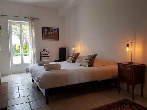 una camera da letto con un letto grande e una finestra di Domaine de Pelouaille - chambre d'hôtes a Saint-Jean-dʼAngély